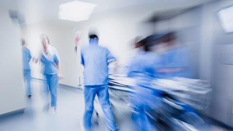 Blurred figures of hospital staff in scrubs rushing a patient to surgery