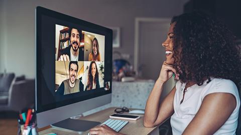 A young woman chats with colleagues in a virtual meeting