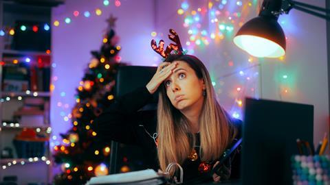 A woman wearing reindeer antlers works at her desk