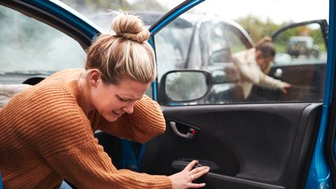 Two women emerge from their cars holding their neck following a collision