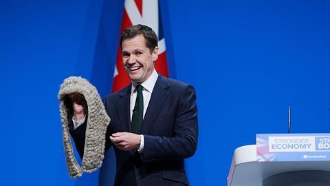 Shadow justice secretary Robert Jenrick removes a judge's wig from a black box as he delivers a speech during the Conservative Party Conference, Manchester, 2025