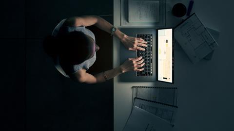 Woman sat at laptop working late at night