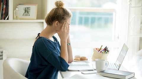 Mental health, stressed woman sat at desk at home
