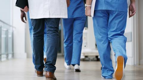 Hospital staff walk down the corridor