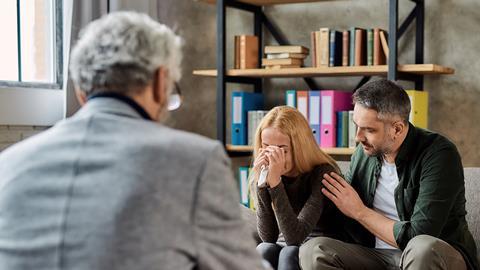 A crying client is comforted during a meeting