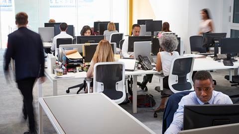 A group of colleagues work at their desks in the office