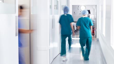 Surgeons wearing scrubs walk to theatre in hospital