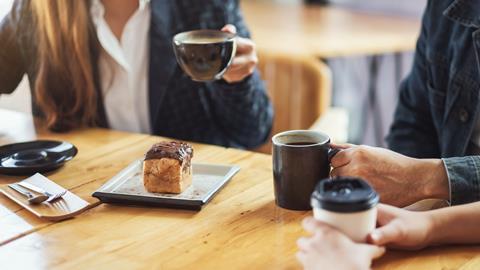 Colleagues chat with coffee and cake