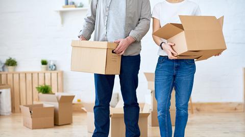 An anonymous couple carry moving boxes