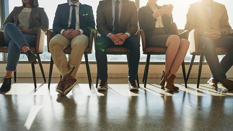 A group of people sit waiting to be seen