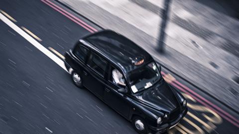 A London cab driving on a road