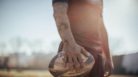 Rugby player holds a rugby ball