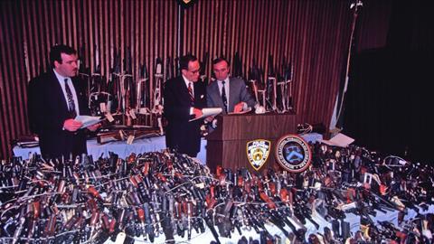 Rudy Giuliani and Bill Bratton pose with guns seized or turned in as part of an initiative to get firearms off the streets of New York