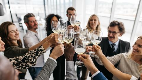 Colleagues clink wine glasses together