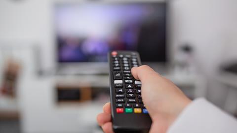 A remote control is pointed at a television