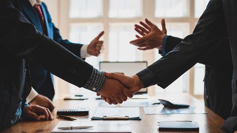 Two parties shake hands in a business meeting