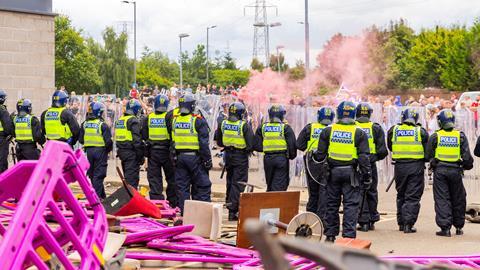 Police attempt to protect a sieged hotel as hundreds of police and rioters clash outside a Holiday Inn Express, Rotherham