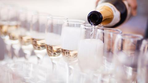 A row of champagne flutes being filled