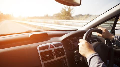 Close up shot of car dashboard with driver behind the wheel