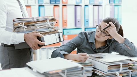 Office worker looks through piles of files