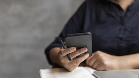 Student studying using phone and laptop