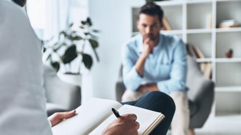 A counsellor takes notes with a client