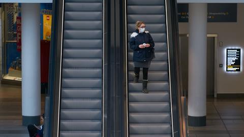 A shopper wearing a face mask in an empty shopping centre