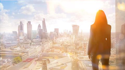 A City worker looks out over the City of London skyline