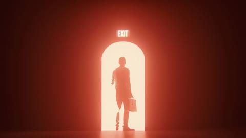 An anonymous man walks through an exit door