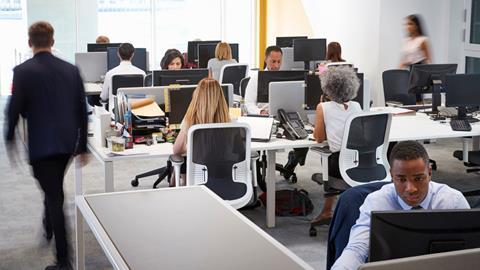 A group of colleagues work at their desks in the office