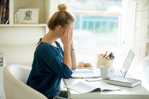 Mental health, stressed woman sat at desk at home