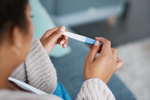 A woman reads a pregnancy test