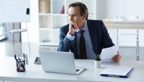 Businessman holds a contract while working at his desk