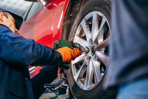 A mechanic replaces a car wheel