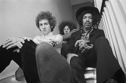 Jimi Hendrix seated on right with, on left, Mitch Mitchell and, behind in centre, Noel Redding
