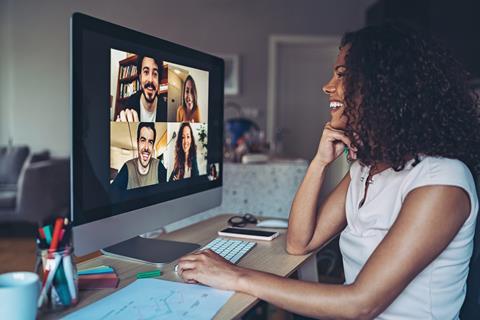 A young woman chats with colleagues in a virtual meeting