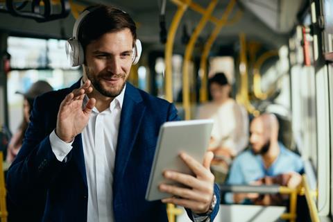 A businessman takes a video call while on a bus