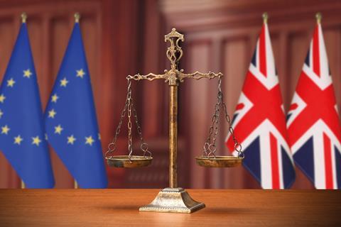 Justice scales with EU and UK flags