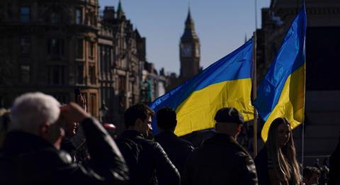 Ukrainian flags wave in Trafalgar Square as people descend to attend a protest, in London