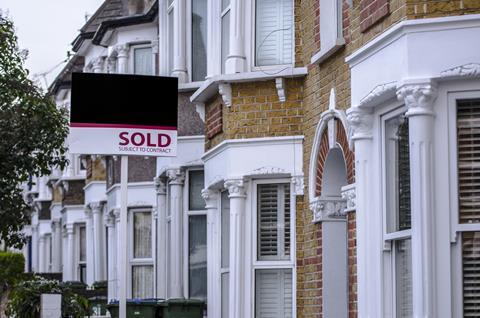 Sold sign outside row of terraced houses