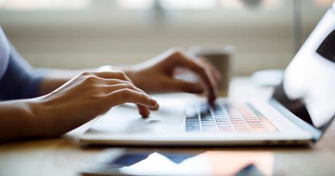 Hands typing on laptop