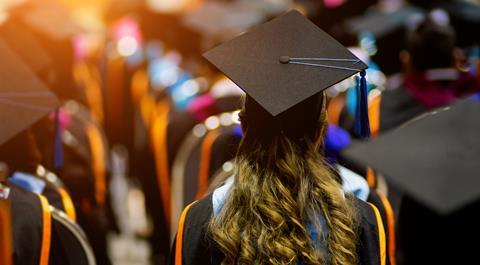 A shot of a student in a crowd wearing a cap and gown