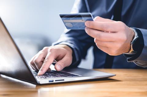 A man types his credit card details on a laptop