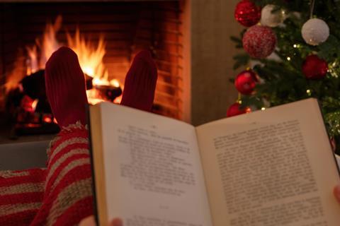 Reading a book by the Christmas tree