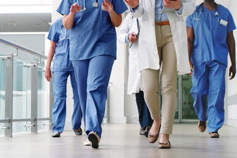 A group of doctors walk down a hospital corridor