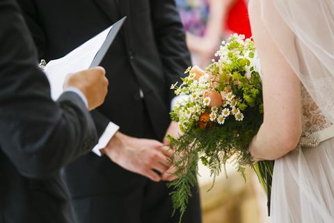 An officiant conducts a wedding ceremony with a bride and groom