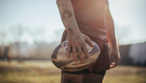 Rugby player holds a rugby ball