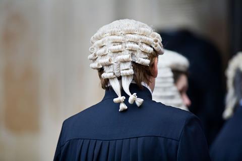 A barrister wears robes and a wig