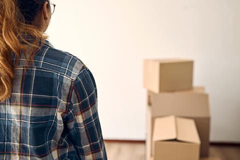 A woman looks at moving boxes