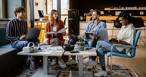 A group of young colleagues chat in the office